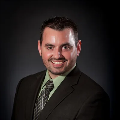 Chris Schmidt smiling in a suit and tie.